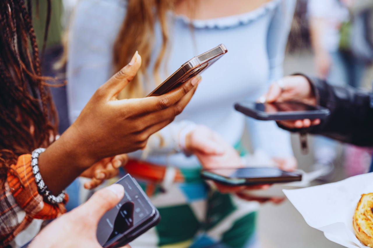a group of teenagers using their phones to access social media